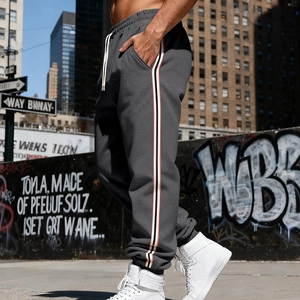 Detail view of charcoal grey joggers featuring side stripes and drawstring waist