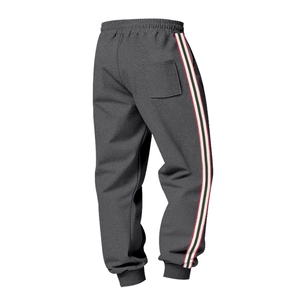 Detail of grey joggers featuring classic side stripe webbing and ribbed elastic cuffs
