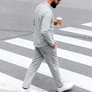 Détail d'un ensemble Henley gris clair pour homme avec texture tricotée et pantalon fluide