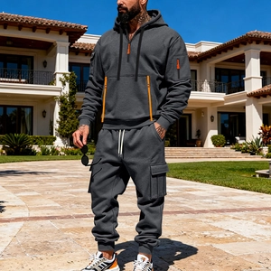 Detail of grey men's hoodie set featuring orange zip accents and cargo joggers