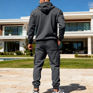 Rear view of charcoal grey men's heavy cotton hoodie and cargo jogger pants set in garden