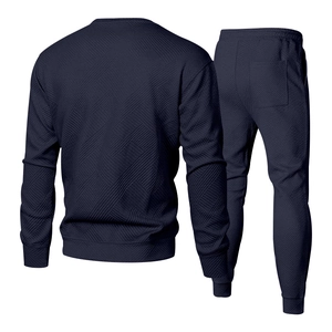 Close-up of navy men's knit tracksuit showing the 3D geometric texture and premium fabric