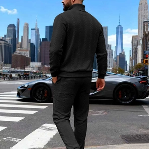 Detailed view of black men's tracksuit with diamond texture fabric and ribbed cuffs