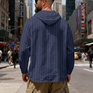 Rear view of man wearing hooded navy blue striped linen shirt in urban street setting