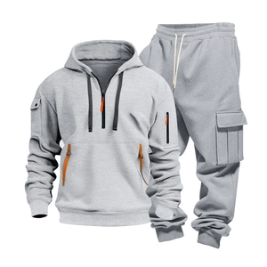 Detail of grey men's tracksuit with hooded sweatshirt, cargo pants and orange zipper accents
