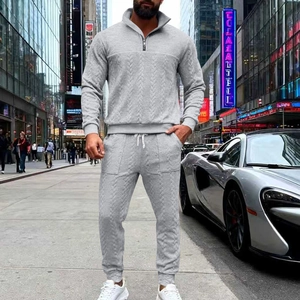 Detail of grey men's tracksuit showing textured knit fabric, zipper collar and drawstring pants