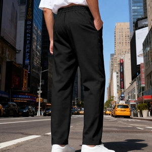 Outdoor street view of men's black straight-cut casual trousers with elastic drawstring waist