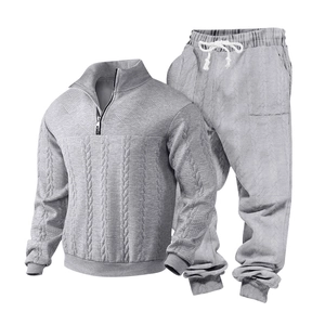 Detail of light grey men's knit tracksuit showing textured cable pattern and zipper