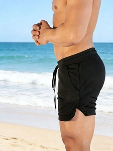 Detail showing elastic drawstring waistband and side slits on black quick-dry gym shorts