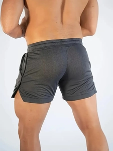 Macro detail of breathable dark gray sports shorts showing side slit and fabric texture