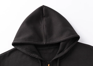 Close-up of black hooded sweatshirt showing orange zipper puller and warm fleece lining