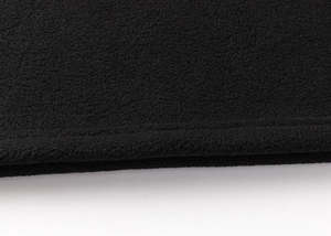 Close-up of thick black polar fleece fabric showing durable stitching and soft texture