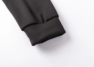 Close-up of black hoodie sleeve with elastic ribbed cuffs and detailed knit stitching