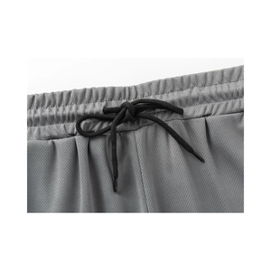 Detail of grey athletic shorts showing breathable mesh fabric and elastic waistband with drawcord