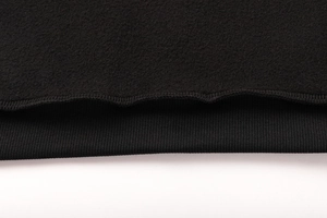 Vista macro dettagliata del tessuto in pile nero e della trama dei polsini in maglia