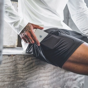 Détail du short de sport double couche montrant la poche téléphone intégrée sur la doublure