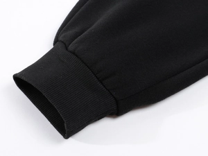 Detailed view of the ribbed cuffs on thick black fleece-lined sweatpants