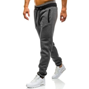 Detail of dark gray joggers with black drawstring waist and zip pocket on model