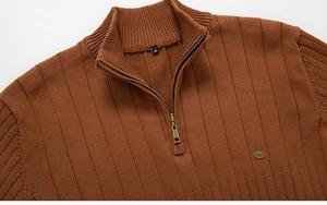 Détail du pull en maille pour hommes avec col montant zippé et logo métallique gravé