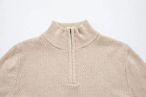 Detail of men's beige half-zip knit sweater showing ribbed stand collar and chevron texture