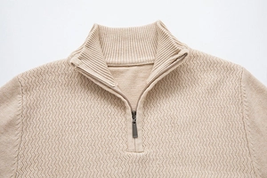Detailed macro view of beige ribbed stand collar and premium zipper on men's knit sweater
