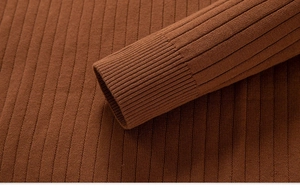Détail du pull en maille caramel montrant la texture côtelée et la finition du poignet