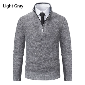 Close-up of light gray waffle knit texture and quarter-zip stand collar on men's sweater