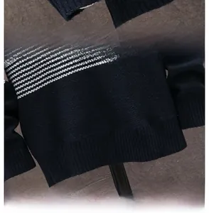 Dettaglio dei polsini elastici a coste e dell'orlo liscio di un maglione in maglia blu scuro