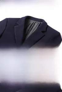 Détail d'un manteau en laine bleu marine avec col à revers et boutons métalliques