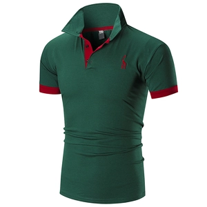Detail of dark green polo shirt featuring contrast red embroidery and ribbed cuffs