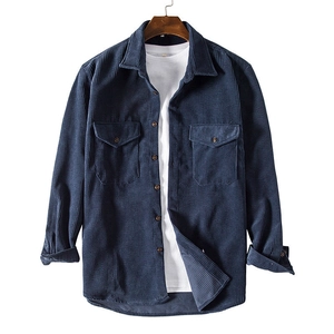 Detail of navy corduroy shirt with double chest pockets and fine ribbed texture