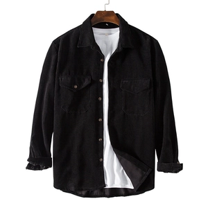Close-up of black corduroy shirt texture with classic buttoned chest pockets and collar