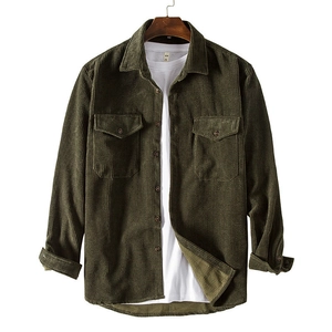 Macro detail of olive green corduroy shirt featuring chest pockets and classic collar