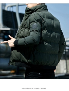 Detail van tijgerkop borduurwerk op de mouw van een groene gewatteerde winterjas