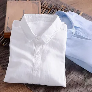 Close-up of white and blue men's linen shirts with natural texture on a bamboo mat