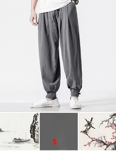 Detail of grey linen harem pants featuring a drawstring waist and tapered cuffs style