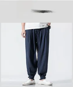 Detail of dark blue linen harem pants featuring retro drawstring waist and cuffed ankles