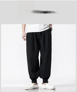 Close-up of black linen harem pants showing fabric texture and tapered ankle cuffs