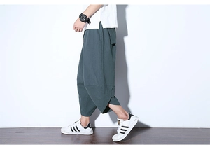 Vista laterale dettagliata dei pantaloni larghi da uomo in lino verde scuro rilassato