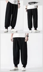 Detail view of black linen harem pants showing drawstring waist and tapered ankle cuffs