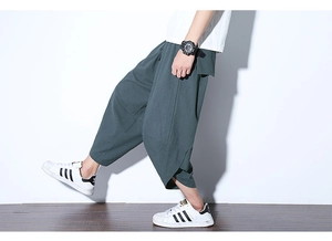 Dettaglio macro dei pantaloni larghi in lino da uomo con texture e orlo irregolare