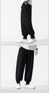 Detail view of black linen harem pants with drawstring waist and buttoned ankles for men