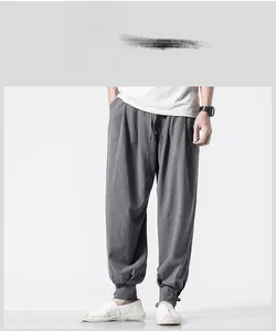 Detailed view of dark grey linen harem pants featuring adjustable buckled ankle cuffs