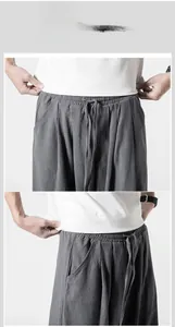 Detailed close-up of elastic waistband with drawstring on men's gray linen pants