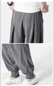 Detail of dark gray linen harem pants featuring traditional Chinese knot buttons at the cuff