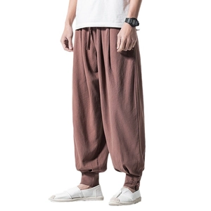 Men's linen harem pants in brick red with drawstring waist and buttoned ankle cuffs