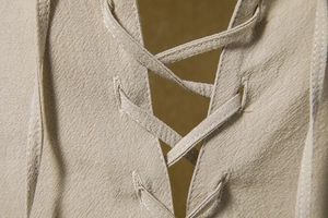 Detail van de vetersluiting V-hals en stiksels op khaki linnen herenshirt voor heren