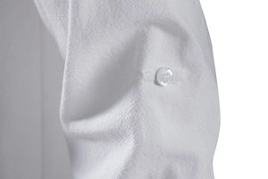 Detail of white cotton linen shirt sleeve featuring adjustable roll-up tab and button