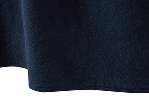 Macro-opname van de marineblauwe katoen-linnen textuur en fijne stiksels op de zoom van het shirt