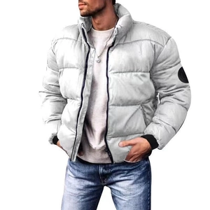 Detail of silver puffer jacket featuring a windproof shell and black knit cuffs